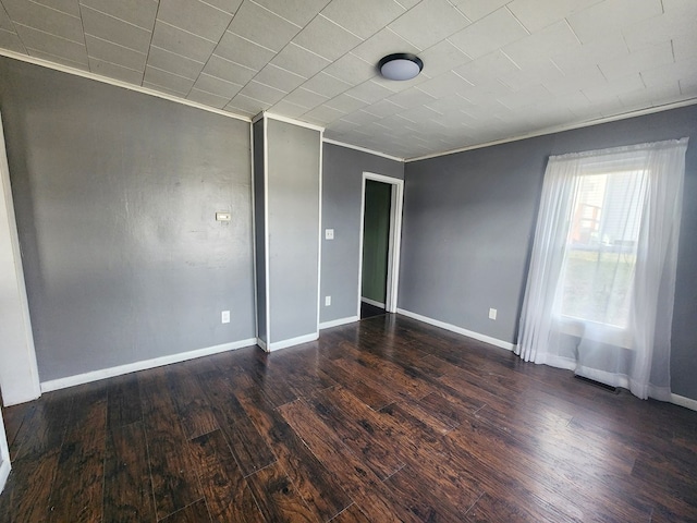 spare room featuring dark hardwood / wood-style flooring and crown molding