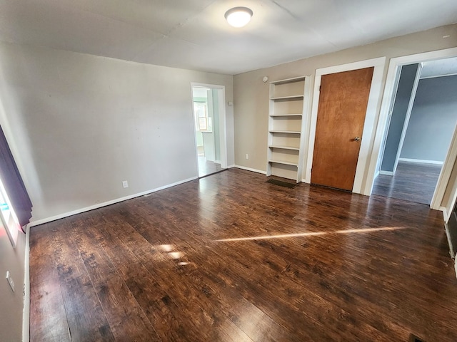 unfurnished bedroom featuring two closets and dark hardwood / wood-style floors