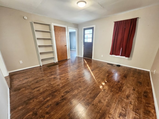 unfurnished bedroom with dark wood-type flooring