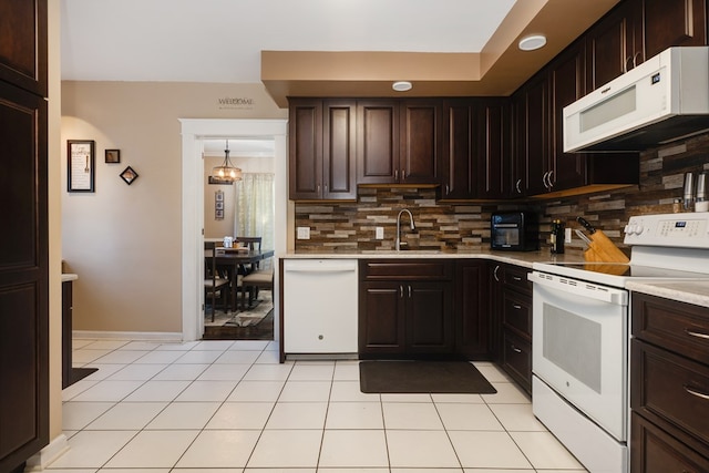 kitchen with sink, decorative light fixtures, white appliances, light tile patterned floors, and decorative backsplash