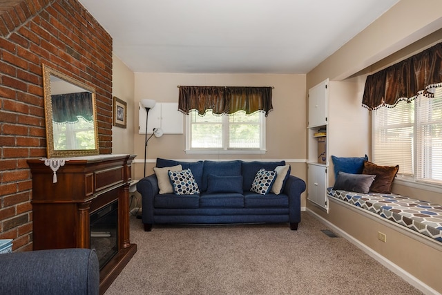 living room featuring a brick fireplace and light carpet