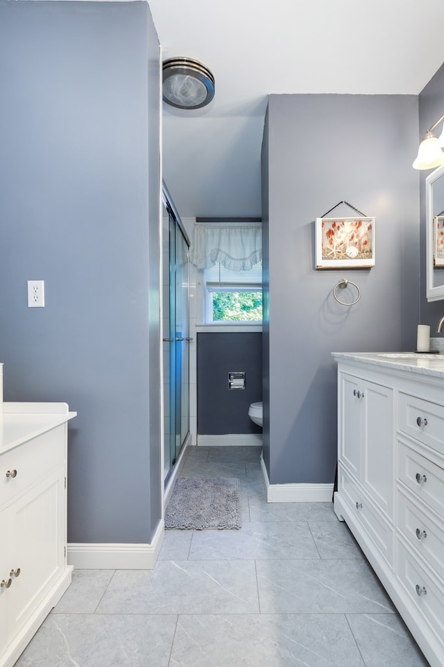 bathroom featuring a shower with door and vanity