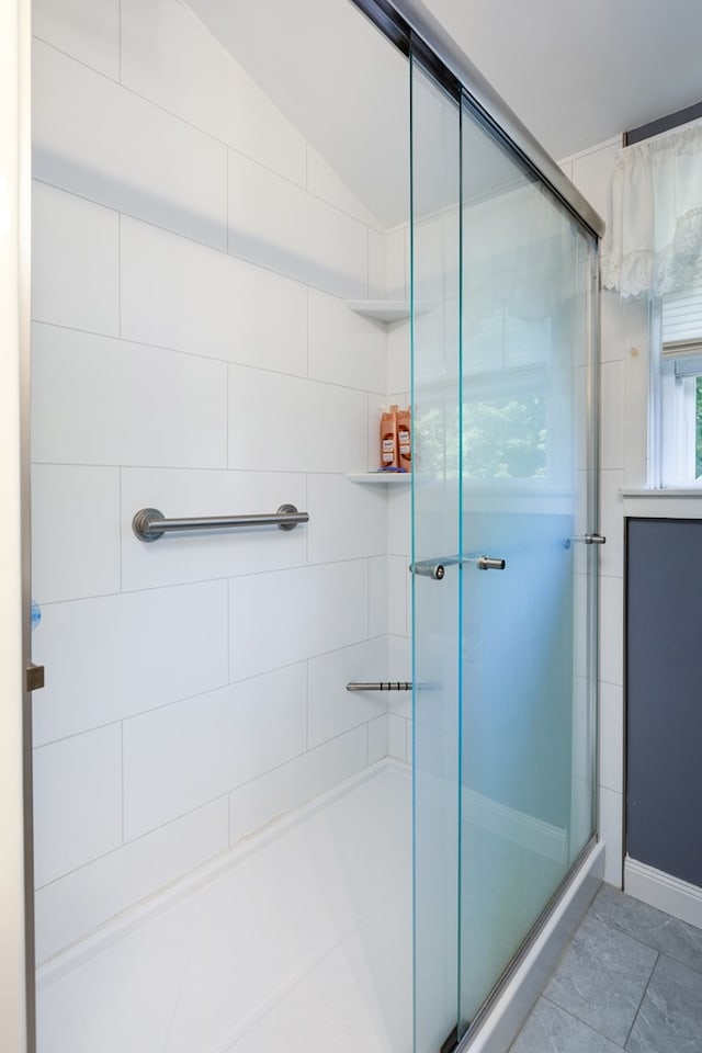 bathroom featuring vaulted ceiling and walk in shower