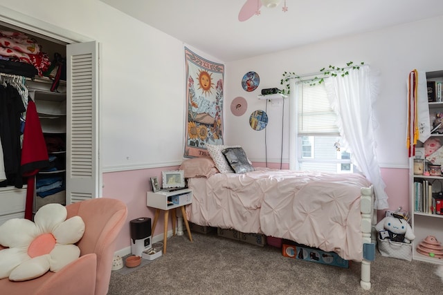 carpeted bedroom featuring ceiling fan and a closet