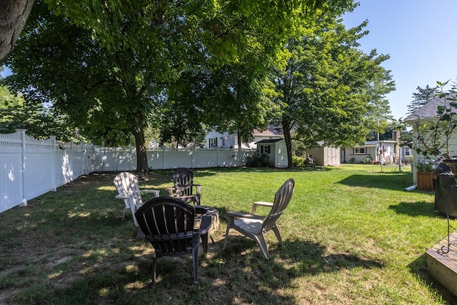 view of yard with an outdoor fire pit and a storage shed