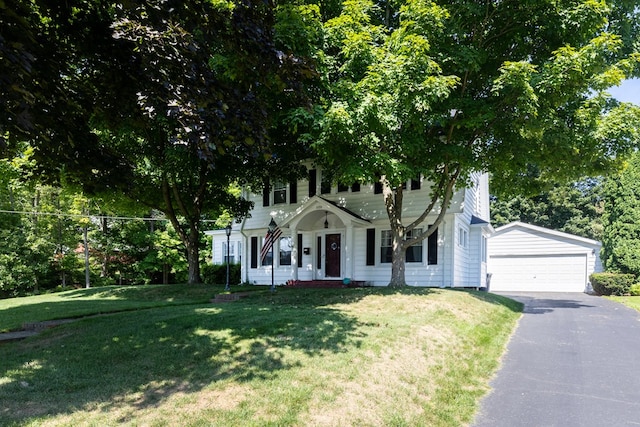 view of front of home featuring a front yard, a garage, and an outdoor structure