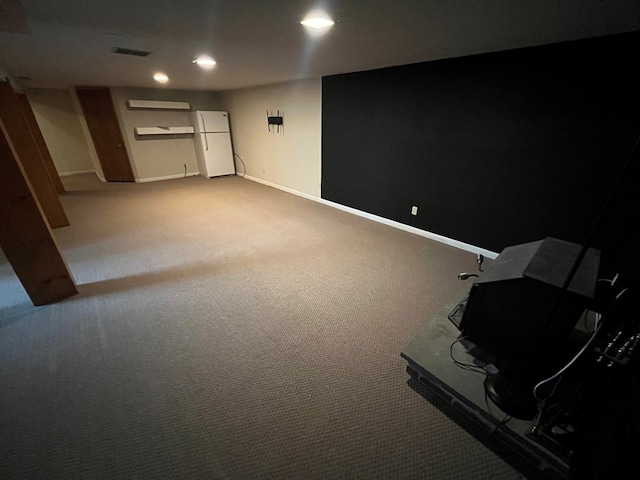 basement with carpet floors and white fridge