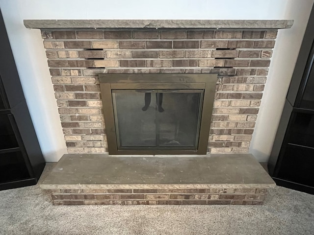 interior details featuring carpet flooring and a brick fireplace