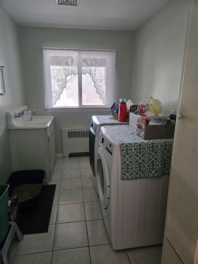 laundry room featuring light tile patterned floors, sink, independent washer and dryer, and radiator heating unit