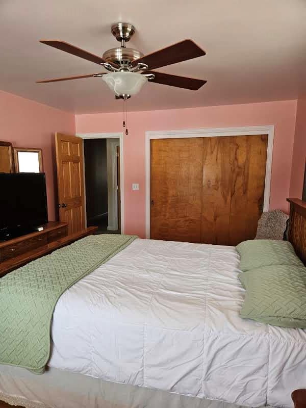 bedroom with ceiling fan and a closet