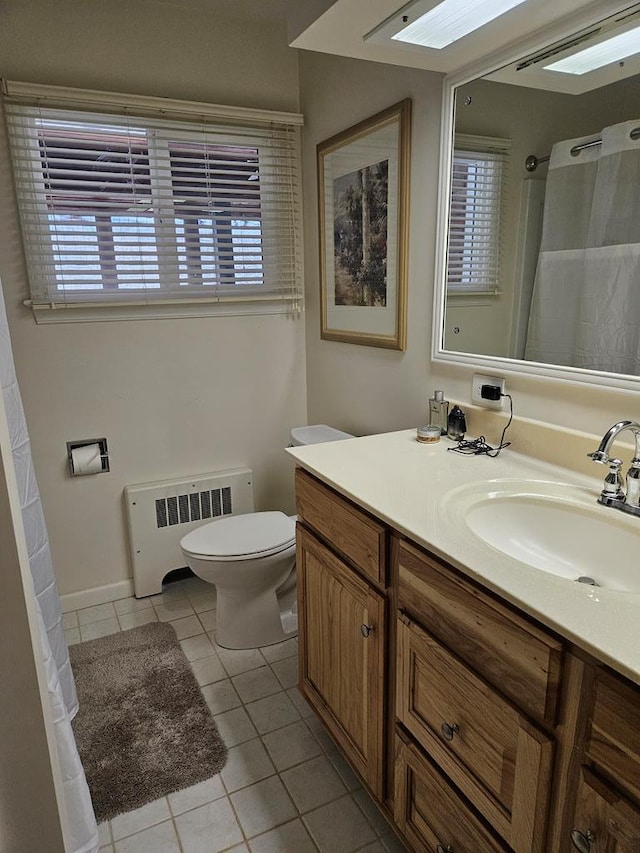 bathroom with tile patterned floors, plenty of natural light, vanity, and radiator heating unit