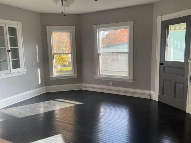 unfurnished dining area featuring ceiling fan, dark hardwood / wood-style flooring, and a baseboard radiator