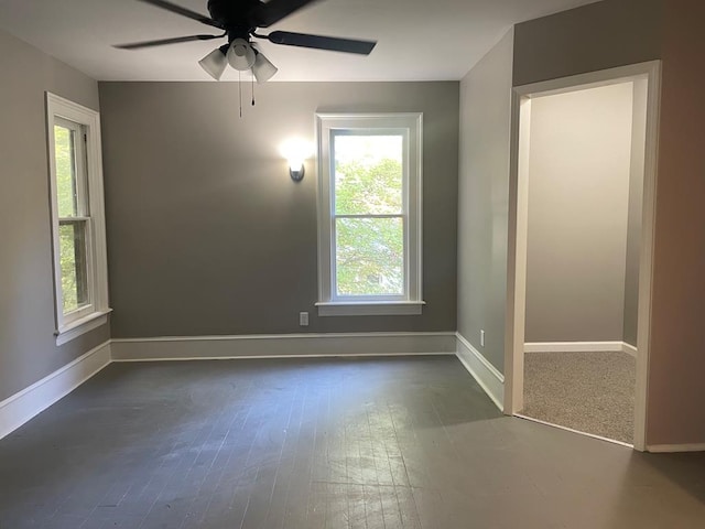 unfurnished room with ceiling fan and dark wood-type flooring