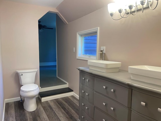 bathroom with vanity, vaulted ceiling, ceiling fan, wood-type flooring, and toilet