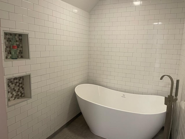 bathroom with a tub and tile walls