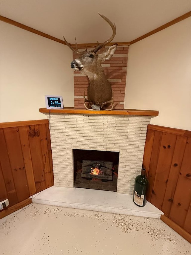 details featuring wooden walls, crown molding, and a brick fireplace