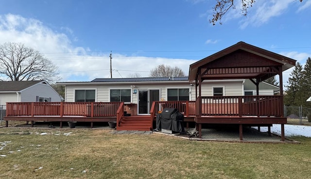 rear view of property featuring a gazebo, a deck, and a lawn