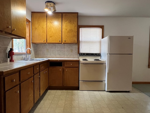 kitchen featuring tile counters, backsplash, sink, and white appliances