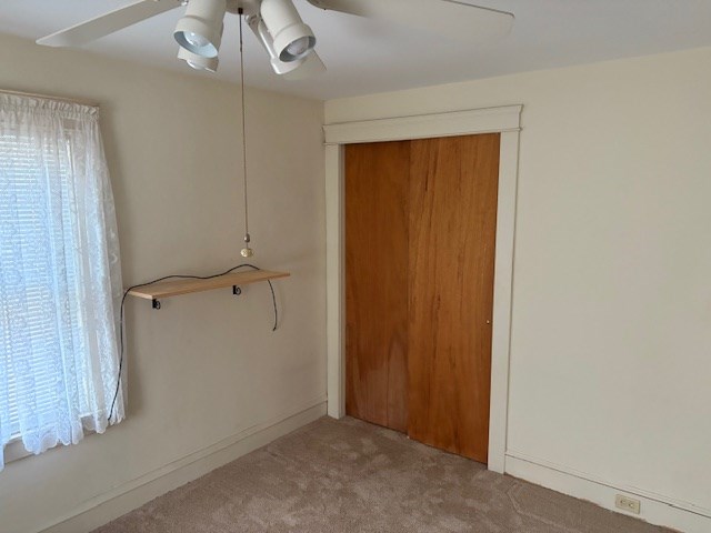 spare room featuring light carpet and ceiling fan