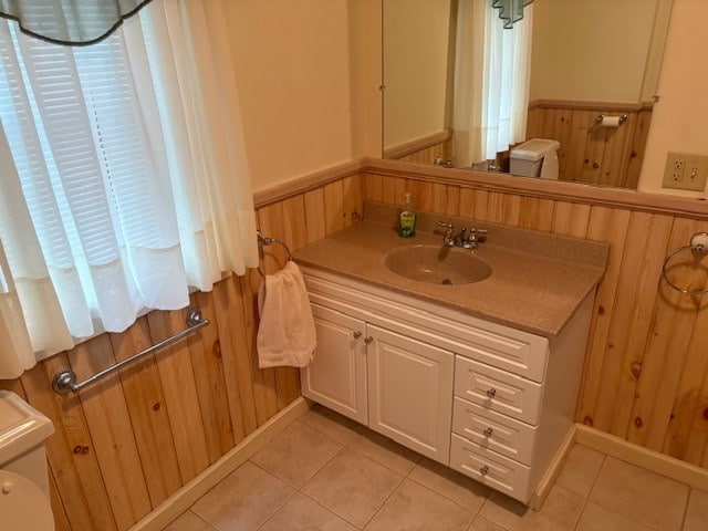 bathroom featuring toilet, wooden walls, and tile patterned floors