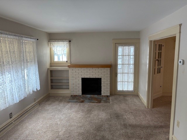 unfurnished living room featuring a fireplace and carpet floors