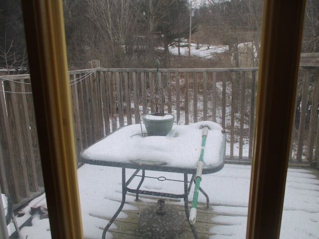 view of snow covered back of property