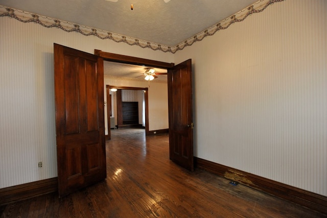 spare room featuring ceiling fan, radiator, a textured ceiling, and dark hardwood / wood-style flooring