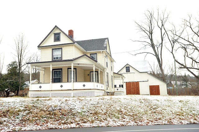 view of front of house with a porch and an outdoor structure