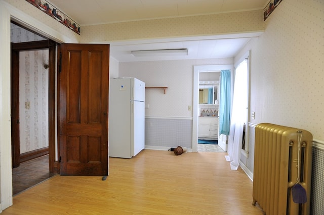 corridor featuring radiator and light hardwood / wood-style flooring