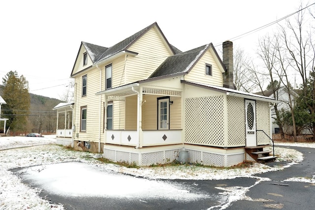 view of snowy exterior with covered porch