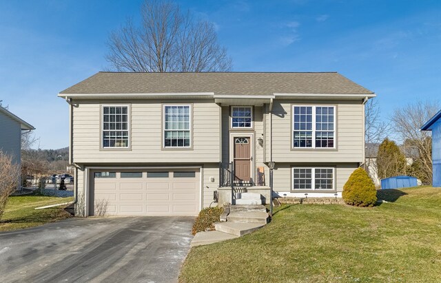 split foyer home featuring a front yard and a garage