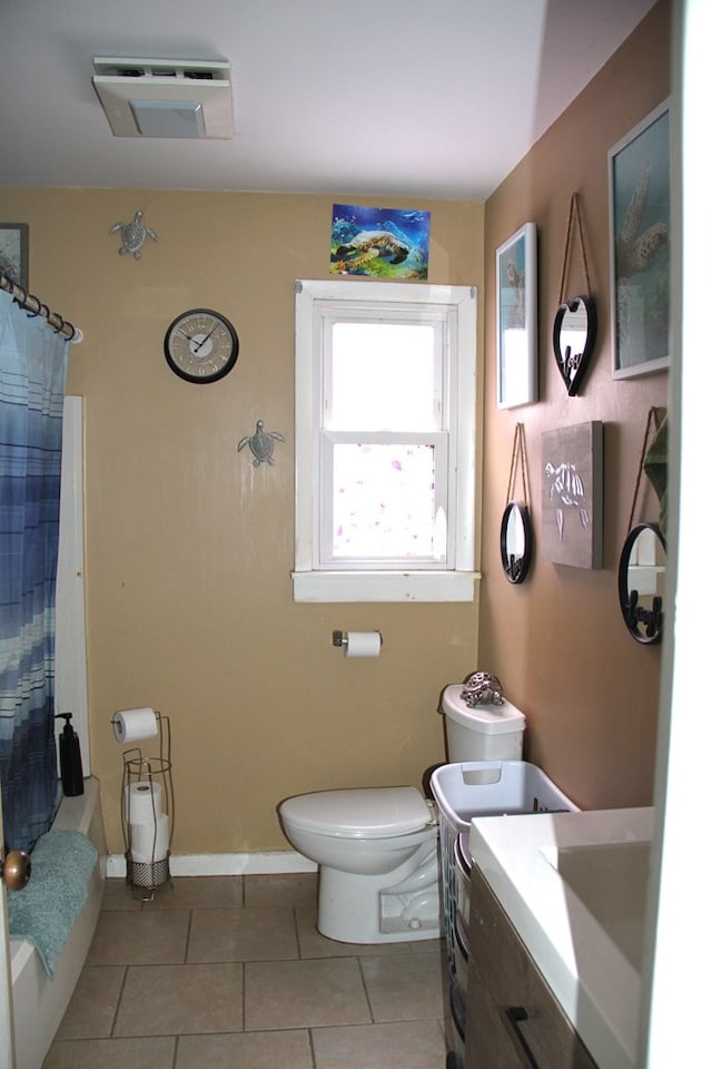 full bathroom featuring vanity, shower / bathtub combination with curtain, tile patterned floors, and toilet