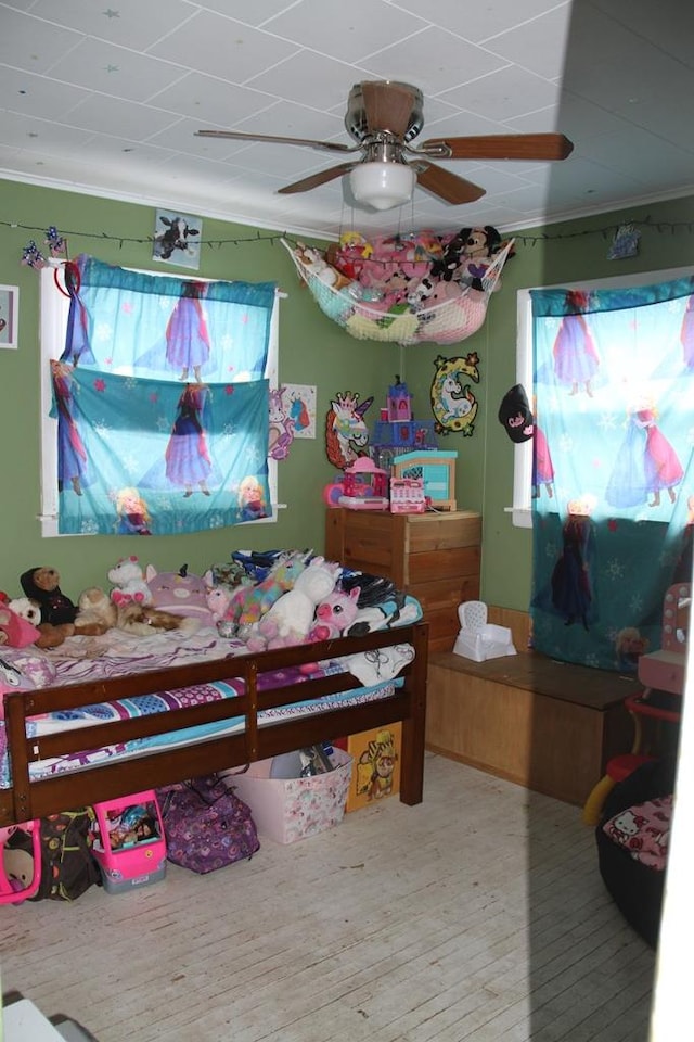 bedroom with hardwood / wood-style flooring, ceiling fan, and crown molding