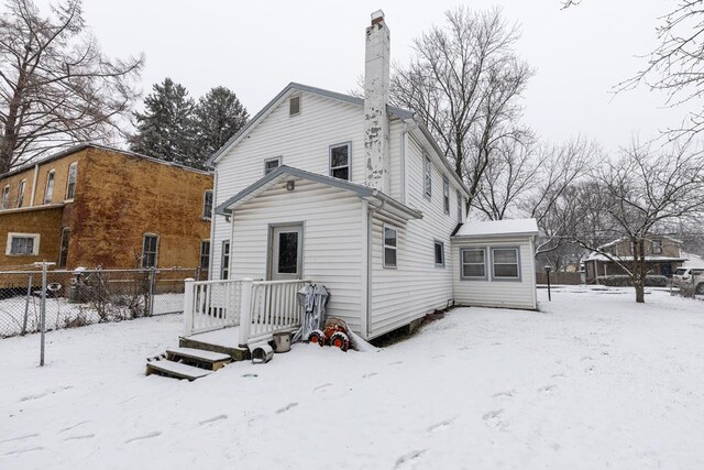 view of snow covered back of property