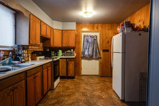 kitchen featuring sink, white refrigerator, and gas stove