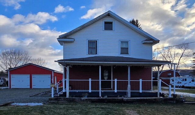 view of front facade with covered porch, a garage, and an outbuilding