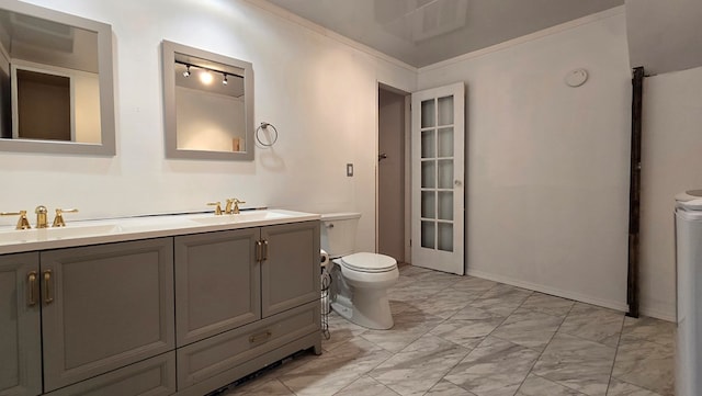 bathroom with vanity, ornamental molding, and toilet