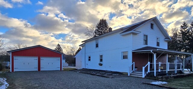 view of front of house with an outbuilding, covered porch, and a garage