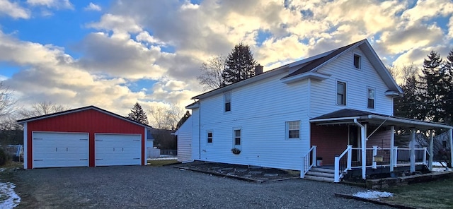 view of front of house featuring a garage, an outbuilding, and covered porch