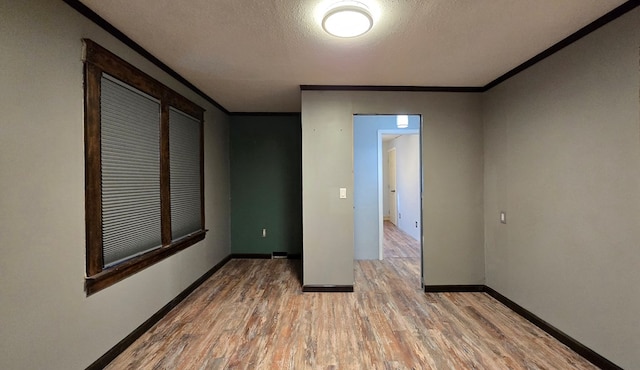 unfurnished room with wood-type flooring, ornamental molding, and a textured ceiling