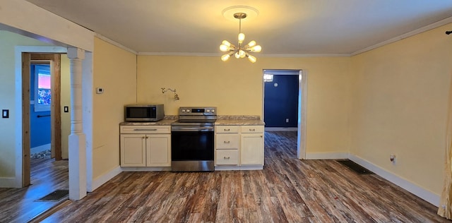 kitchen featuring dark wood-type flooring, ornamental molding, a notable chandelier, stainless steel appliances, and light stone countertops