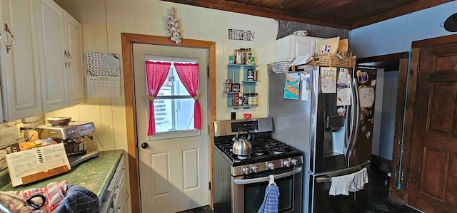 kitchen with stainless steel appliances, wooden walls, wooden ceiling, and white cabinetry