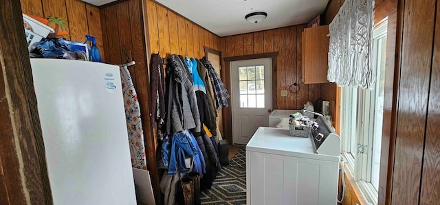 laundry room with independent washer and dryer and wooden walls