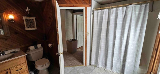 bathroom featuring vanity, wooden walls, toilet, and curtained shower