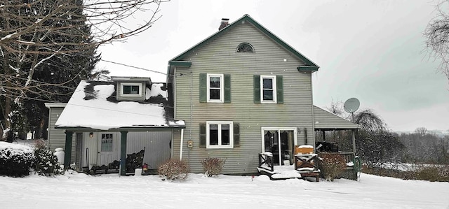 view of snow covered rear of property