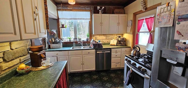 kitchen featuring white cabinets, appliances with stainless steel finishes, a healthy amount of sunlight, and sink