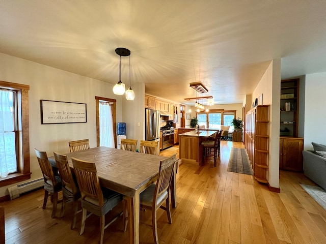 dining space with light hardwood / wood-style flooring and baseboard heating