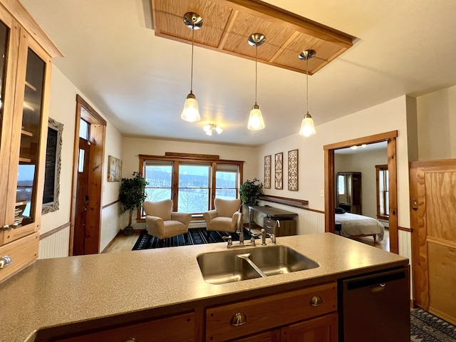 kitchen with decorative light fixtures, dishwasher, and sink