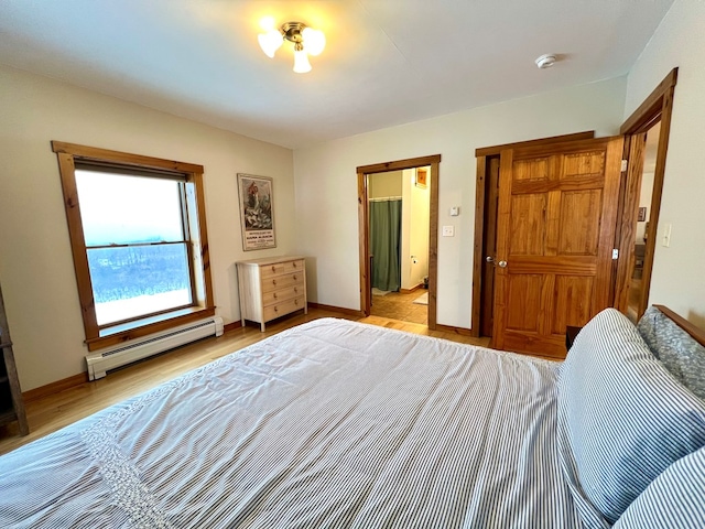 bedroom with baseboard heating and light hardwood / wood-style flooring