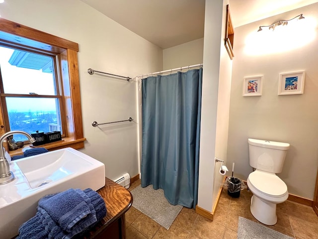 bathroom featuring walk in shower, sink, baseboard heating, and toilet